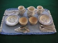 a table set with dishes and silverware on a blue placemat