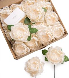 white flowers are in a box with green leaves on the top and one flower has been cut into smaller pieces