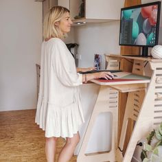 a woman standing in front of a computer desk