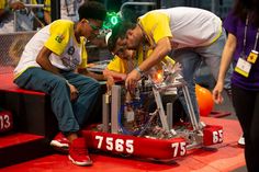 three men working on an engine in a competition