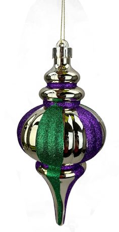 a glass ornament with a green and purple ribbon hanging from it's side