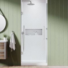 a white shower sitting next to a bathroom sink and mirror on a green painted wall