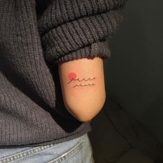 a person with a small tattoo on their left arm and the word love written in cursive writing