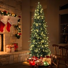 a lit christmas tree in front of a fireplace