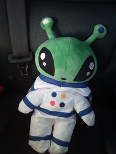 a stuffed toy in the back seat of a car wearing an astronaut suit with polka dots on it