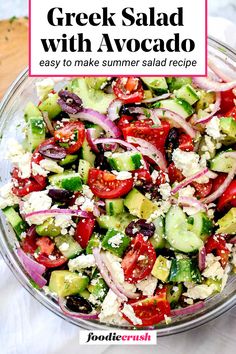 greek salad with avocado and red onions in a glass bowl on a table