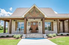 a house with stone and wood accents on the front porch