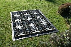 a large metal grate sitting on top of a lush green field