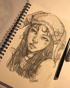 a drawing of a girl with a hat on her head and eyes closed, next to a pencil