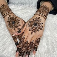 two hands with henna tattoos on them