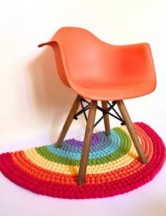 an orange chair sitting on top of a colorful rug