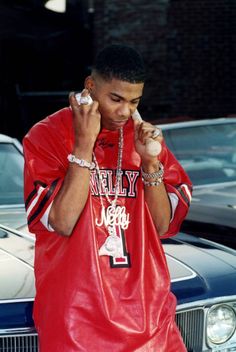 a young man wearing a red leather jacket and holding a baseball in his right hand