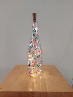 a bottle that is sitting on a table with some lights in the shape of dots