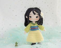 a crocheted doll is standing in the snow