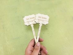 someone is holding two wooden spoons that say let love, let love grow