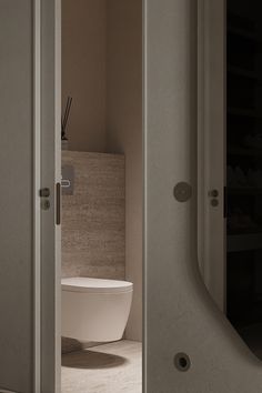 an open door leading to a bathroom with a toilet in the corner and several pairs of shoes on the shelves