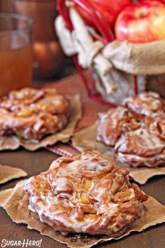 apples and cinnamon rolls sitting on top of brown paper