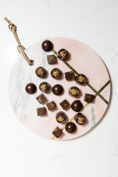 some chocolates are on a white plate with a brown caramel stick in the middle