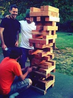 two men are building a tower made out of wood