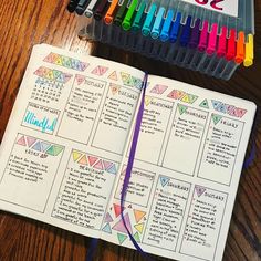 an open notebook with colored markers next to it on a wooden table and some school supplies