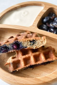 two waffles on a plate with blueberries and yogurt