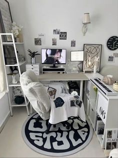 a white desk topped with a laptop computer next to a keyboard and monitor on top of a rug