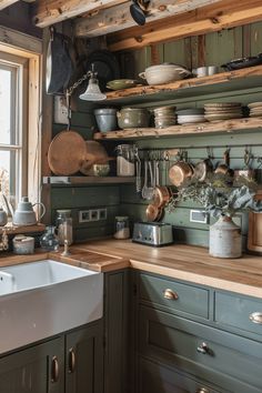 a kitchen filled with lots of pots and pans on top of shelves next to a window