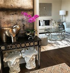 a living room filled with lots of furniture and flowers on top of a coffee table