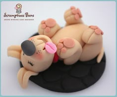 a cake shaped like a sleeping dog on top of a black plate with pink accents