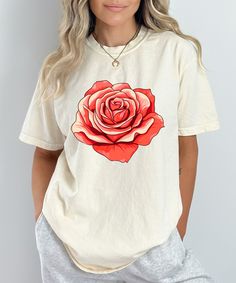 Add a touch of elegance to your wardrobe with this stunning floral design shirt featuring a vibrant red rose. Perfect for those who love nature-inspired fashion, this flower graphic tee is both stylish and versatile, making it a great choice for casual outings or dressing up with accessories. Crafted from high-quality, soft fabric, this botanical print t-shirt ensures comfort and durability. The bold rose design stands out beautifully against the black background, making it a statement piece that's sure to draw compliments. Whether you're a plant lover, a fan of floral patterns, or simply looking for a unique gift for her, this floral t-shirt for women is a perfect addition to any wardrobe. Key Features: Premium Quality: Made from soft, breathable fabric for all-day comfort. Vibrant Design Spring Cotton T-shirt With Rose Print, Rose Print Tops For Spring, Rose Print Tops For Summer, Trendy Rose Print T-shirt For Spring, Spring Graphic Tee With Rose Print, Summer Graphic Tee With Rose Print, Spring Rose Print Graphic Tee, Summer Short Sleeve T-shirt With Rose Print, Summer Rose Print Short Sleeve T-shirt