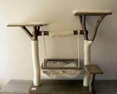 the cat tree is made out of wood and has two cats on it's perches