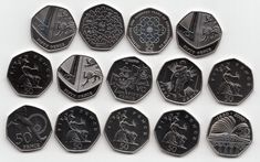 twelve different types of silver coins on a white surface, including one with an image of the zodiac sign