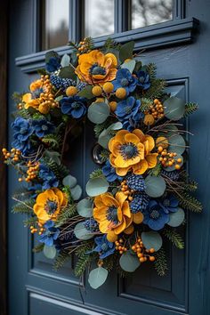 a wreath with yellow and blue flowers hanging on the front door to decorate it's entrance