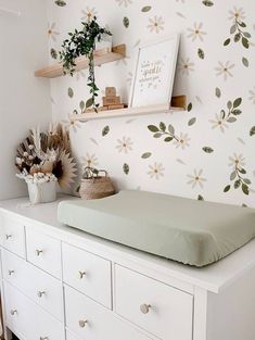 a baby's crib with flowers on the wall