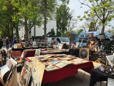 an outdoor flea market with tables covered in art