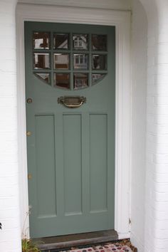 an image of a green front door with glass inserts on the top and bottom