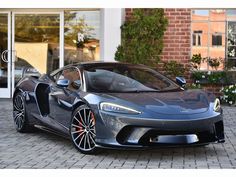 a grey sports car parked in front of a building