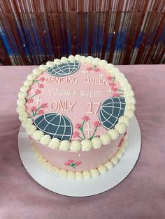 a pink and white cake sitting on top of a table