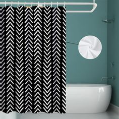 a black and white shower curtain hanging in a bathroom next to a bathtub with a toilet