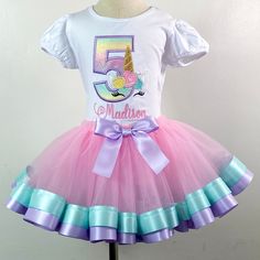 Cute Unicorn Custom Outfit / includes the shirt with your childs age, and name. Ages 1-9 are available. The tutu is made of tulle and ribbon.  I also offer the Shirt and Tutu separately Please select in the "options" menu prices do vary.  I offer short and long sleeve shirts. SS = Short Sleeve LS = Long Sleeve I use  Boutique quality shirt for all embroidery. They have PUFF sleeves. They are 100% Combed Cotton SUPER SOFT and run TRUE TO SIZE.  The tutu is made with a soft sheer tulle material and satin ribbon trim. Elastic for the waistband so the tutu stretches and can fit wider. I use a soft mesh on the backing of the embroidered design to make it soft to the touch for your little one. Machine wash Cold and Hang Dry. ** FREE SHIPPING ON OUTFITS ONLY.  Outfit ships with USPS Priority 1-4 Unicorn Birthday Outfit Girl, Cute Unicorn Print Tutu Dress For Birthday, Rainbow Unicorn Birthday Shirt, Custom Unicorn Birthday Shirts, Cute Unicorn Print Tutu Dress For Dress-up, Unicorn Birthday Outfit, Tulle Material, Magical Birthday, Unicorn Shirt