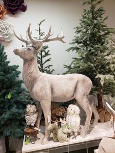 a white deer statue surrounded by stuffed animals