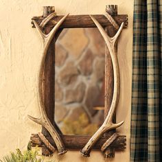 an antler's head is mounted to the side of a mirror