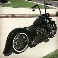 a black motorcycle parked on top of a sidewalk