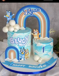 a birthday cake with blue frosting and cartoon characters on it