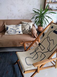 a living room with a couch, chair and potted plant