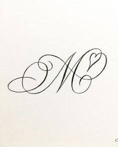 the letter m is inscribed in cursive writing with black ink on white paper