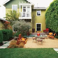 an outdoor patio with chairs and tables in front of a green house on a sunny day