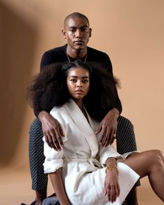 a man sitting next to a woman in a bathrobe on top of a chair