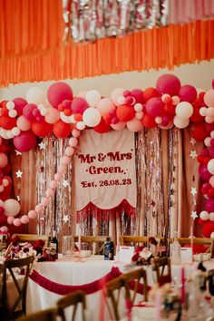 a table set up for a party with balloons and streamers