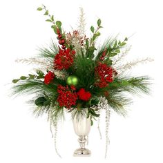 a white vase filled with red flowers and greenery